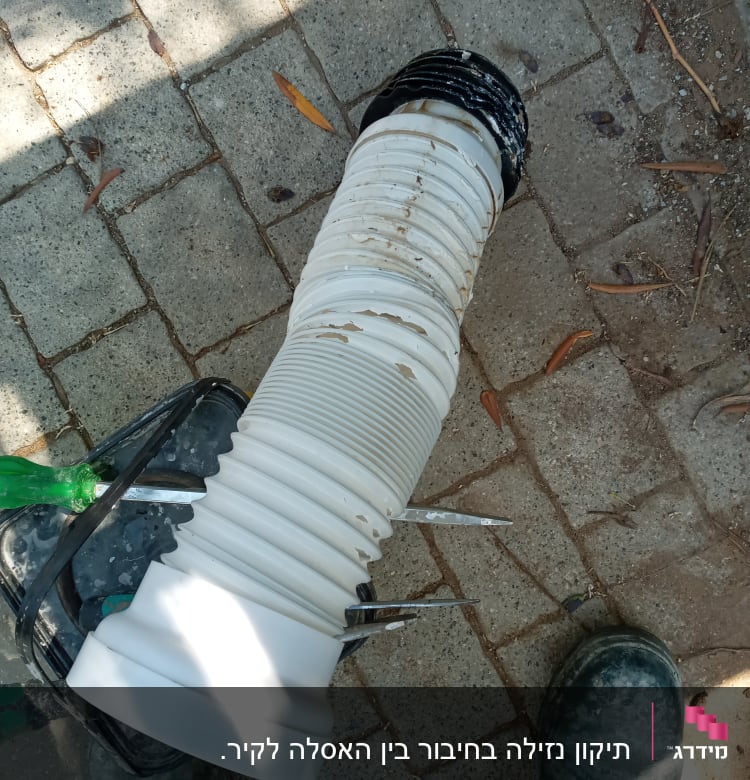 צינור גמיש לבן עם כלי עבודה על רצפה